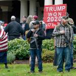 In Jan. 6 photo at the Capitol in Olympia, two men stand armed with guns in front of the Governors Mansion during a protest supporting President Donald Trump and against the counting of electoral votes in Washington, D.C. (AP Photo/Ted S. Warren, File)