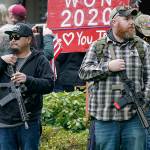 FILE - In this file photo taken Jan. 6, 2021 at the Capitol in Olympia, Wash., two men stand armed with guns in front of the Governor's Mansion during a protest supporting President Donald Trump and against the counting of electoral votes in Washington, DC, affirming President-elect Joe Biden's victory. The open carry of guns and other weapons would be banned on the Washington state Capitol campus and at or near any public demonstration across Washington under a measure that received a remote public hearing Tuesday, Jan. 26, 2021 by the Senate Law and Justice Committee. (AP Photo/Ted S. Warren, File)