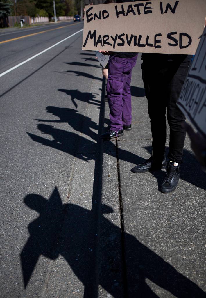 Protestors stand along 80th Street NE in front of the Marysville School District Service Center on Wednesday. (Olivia Vanni / The Herald)