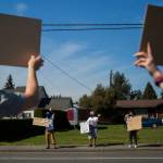 Protestors stand along 80th Street NE in front of the Marysville School District Service Center on Wednesday. (Olivia Vanni / The Herald)