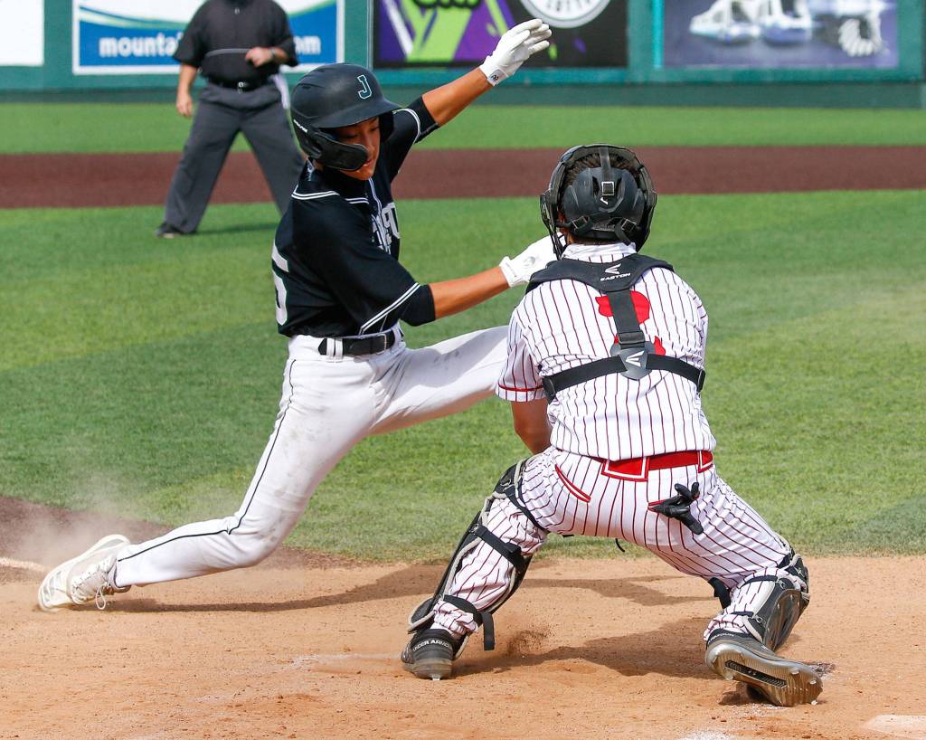 Cascades Andrew Cisneros (right) tags out Jacksons Ryan Nakajima during a game April 23, 2021, at Everett Memorial Stadium. (Kevin Clark / The Herald)
