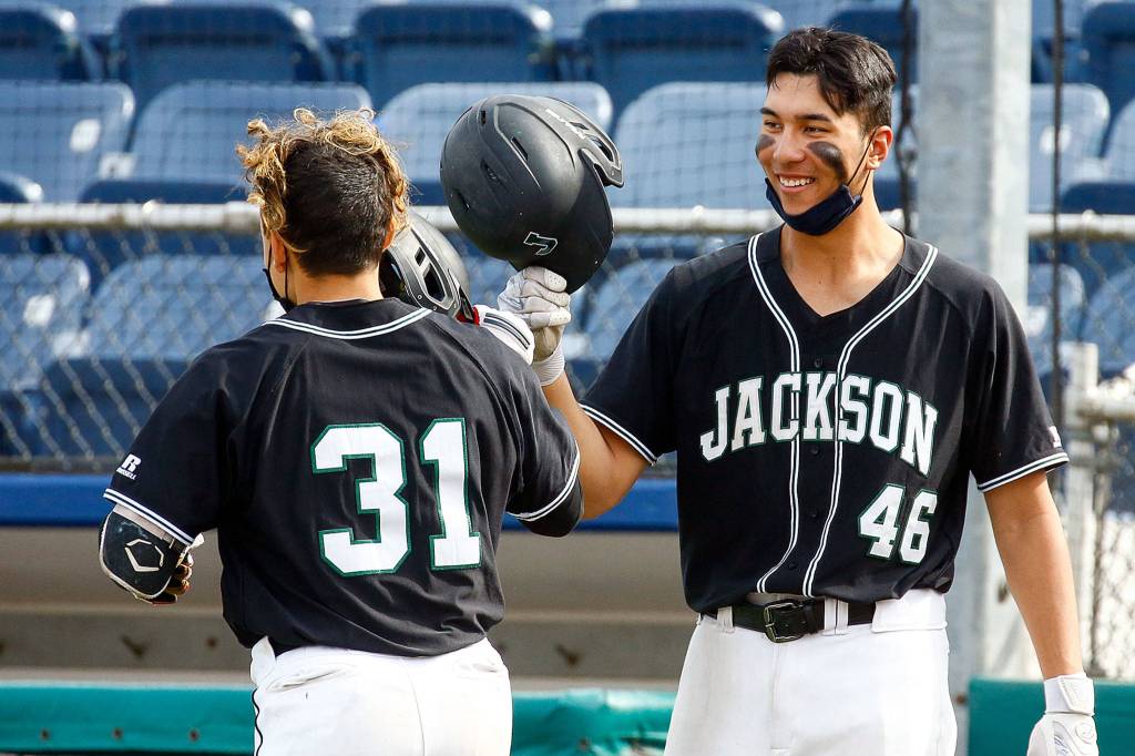 Jacksons Ryan Contreras (31) is welcomed by teammate Dominic Hellman after Contreras home run during a game against Cascade on April 23, 2021, at Everett Memorial Stadium. (Kevin Clark / The Herald)