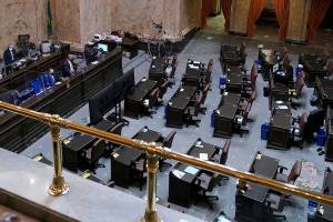 Speaker of the House Laurie Jinkins, D-Tacoma, left, presides over a session of the House, with most representatives attending remotely, Wednesday, April 21, 2021, at the Capitol in Olympia Wash. Lawmakers were considering a proposed new tax in Washington state on capital gains that would be imposed on the sale of stocks and bonds in excess of $250,000. (AP Photo/Ted S. Warren)