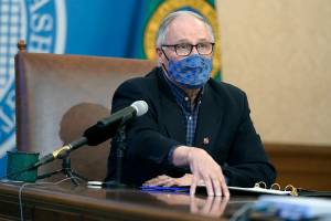 Washington Gov. Jay Inslee speaks during a news conference Thursday, March 11, 2021, at the Capitol in Olympia, Wash. Inslee said that the Seattle Mariners baseball team, the Seattle Sounders MLS soccer team and the National Women's Soccer League's OL Reign will soon be able to welcome a limited number of fans to their stadiums under a 25% seating capacity when they open their seasons. The easing of restrictions will also apply to high school sports, and was one of several aspects of the state's ongoing re-opening plan developed during the COVID-19 pandemic that were announced Thursday. (AP Photo/Ted S. Warren)