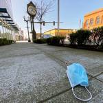 An abandoned face mask rests on the sidewalk along Hewitt Avenue in downtown Everett on April 15. (Sue Misao / The Herald)