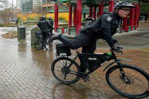 Seattle Police officers head out on bicycles after taking part in a public roll call at Hing Hay Park in the heart of Seattle's Chinatown-International District Thursday, March 18, 2021, at the start of their shift as part of a community response unit. Due to recent episodes of violence and bias against Asians in Seattle and nationwide, law-enforcement presence in heavily Asian neighborhoods has increased, and the group of officers recently began starting some of their shifts at the park before working foot and bicycle patrols in the area to increase security and visibility. (AP Photo/Ted S. Warren)