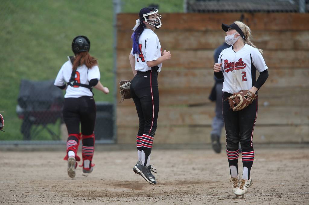 Marysville Pilchuck pitcher Kelsey Harris (left) and teammate Cassidy Phelps jump around before the start of an inning of a game against Jackson on April 28, 2021, in Mill Creek. Jackson beat Marysville Pilchuck 6-0. (Andy Bronson / The Herald)
