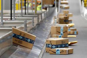 FILE - In this Dec. 17, 2019, file photo, Amazon packages move along a conveyor at an Amazon warehouse facility in Goodyear, Ariz. Amazon’s pandemic boom isn’t showing signs of slowing down. The company said Thursday, April 29, 2021, that its first-quarter profit more than tripled from a year ago, fueled by the growth of online shopping. It also posted revenue of more than $100 billion, the second quarter in row that the company has passed that milestone. (AP Photo/Ross D. Franklin, File)