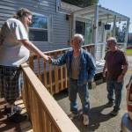 Standing on a new ramp to his home, Doug Waddell shakes hands with Dennis Taylor and Dan Barmon on April 15 in Sultan. Taylor and Barmon built the ramp for Waddell in exchange for two apple pies cooked up by Waddells mom and a friend. (Andy Bronson / The Herald)