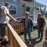 Standing on a new ramp to his home, Doug Waddell shakes hands with Dennis Taylor and Dan Barmon on April 15 in Sultan. Taylor and Barmon built the ramp for Waddell in exchange for two apple pies. (Andy Bronson / The Herald)
