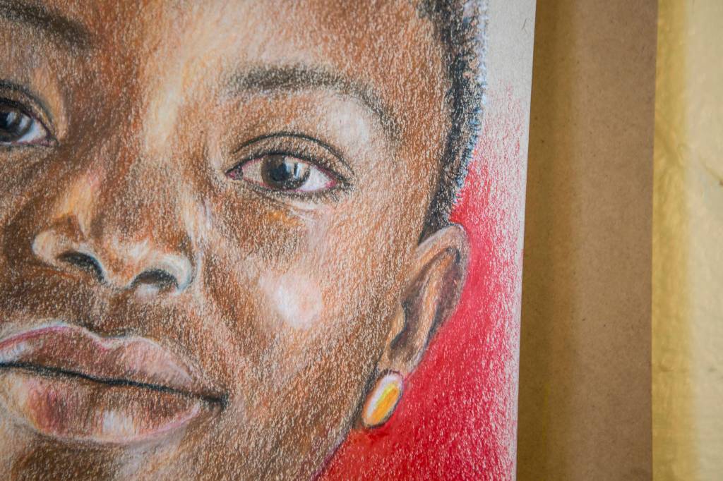 Cathy Tanasse uses a variety of colored pencils and colored backgrounds for her Memory Project portraits. (Olivia Vanni / The Herald)