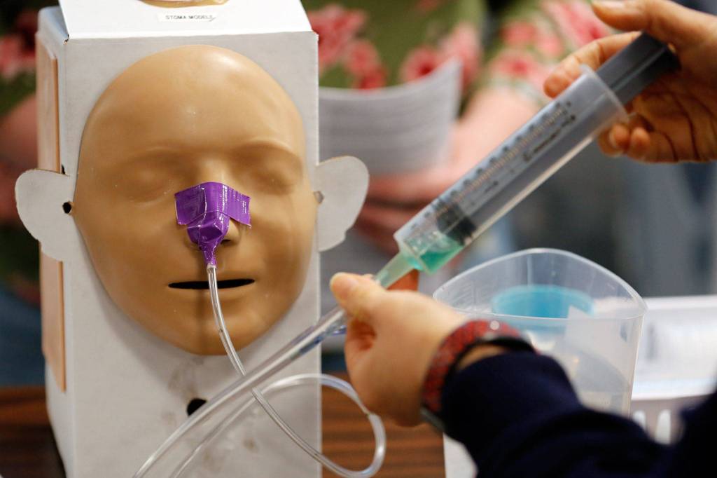 Students use a modular skills trainer during class at Edmonds College on April 29. (Kevin Clark / The Herald)