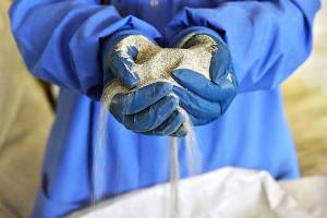 Highland Simulant, a simulated lunar soil made by Off Planet Research, pours from a researcher's hands. Photo credit: Off Planet Research