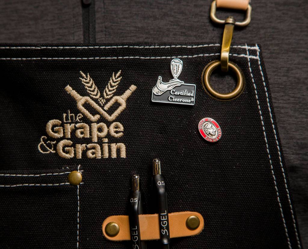 The Grape & Grain owner Eric Brown wears a Guild of Sommeliers pin on his vest. Brown curated wines for Holland America Cruise line before the pandemic struck. (Andy Bronson / The Herald)