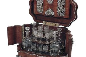 This oak 19th-century "cave a liqueur" holds four decanters and 16 liqueur glasses. It is decorated with silvered mounts of hunting dogs. The 11-inch-high box sold at New Orleans Auction Galleries for $4,250. (Cowles Syndicate Inc.)