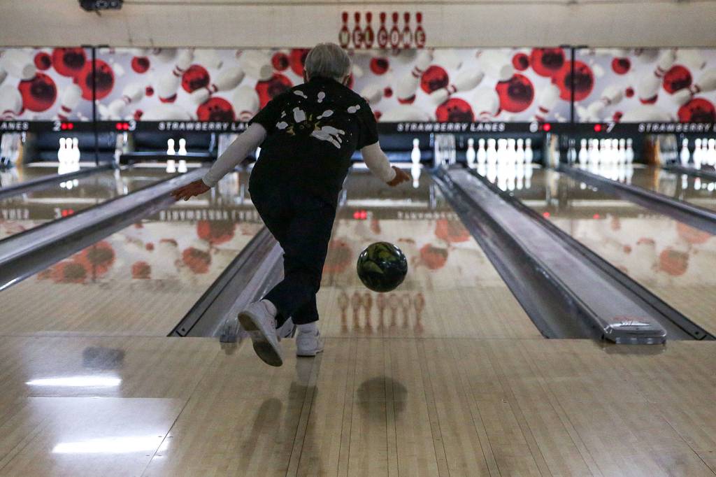 Mae Tomita picks up a spare in the first frame Wednesday afternoon at Strawberry Lanes in Marysville, where family and friends celebrated her 100th birthday. (Kevin Clark / The Herald)