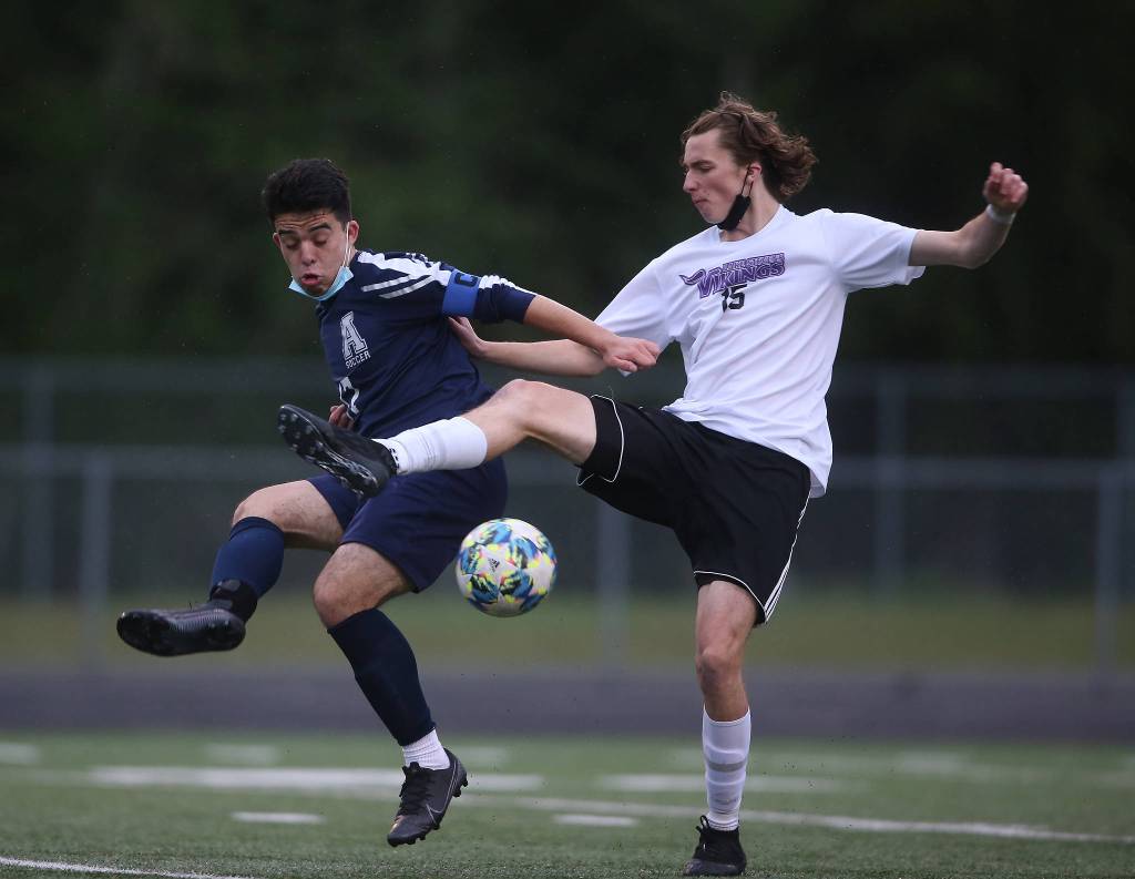 Arlingtons Juan Castillo and Lake Stevens Jordan Ross try to get control of the ball as Arlington beat Lakes Stevens 2-1 in a boys soccer match on Monday, May 3, 2021 in Arlington, Washington. (Andy Bronson / The Herald)