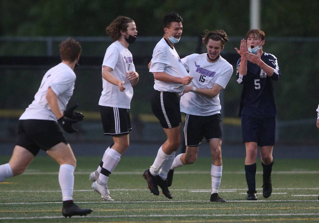 Lake Stevens Ryan Harden (center) celebrates a goal with teammates as Arlingtons Aidan Raney (5) argues for a handball call. Arlington beat Lakes Stevens 2-1 in a boys soccer match on Monday, May 3, 2021 in Arlington, Washington. (Andy Bronson / The Herald) Lake Stevens Ryan Harden (center)