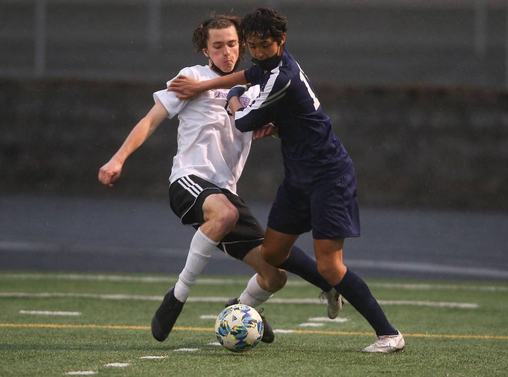 Lake Stevens Jordan Ross and Arlingtons Gio Castillo battle for the ball as Arlington beat Lakes Stevens 2-1 in a boys soccer match on Monday, May 3, 2021 in Arlington, Washington. (Andy Bronson / The Herald)