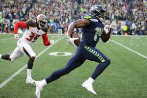 FILE - Seattle Seahawks wide receiver DK Metcalf, right, runs to score a touchdown ahead of Tampa Bay Buccaneers defensive back Jamel Dean during the second half of an NFL football game in Seattle, in this Sunday, Nov. 3, 2019, file photo.  Seahawks wide receiver DK Metcalf is explosive off the line of scrimmage. But Sunday, May 9, 2021, he will venture into a new sort of lane to test his speed on a different sort of line, one that's filled with Olympic-caliber sprinters. (AP Photo/Scott Eklund, File)