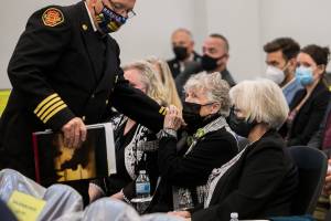 Kathy Parks reaches out to hold Bruce Hansen's hand after his statement during Elmer Nash's sentencing hearing, that Nash failed to show up to, at the Snohomish County Courthouse on Friday, May 7, 2021 in Everett, Wash. (Olivia Vanni / The Herald)