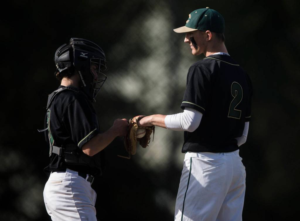 Marysville Getchells Keegan Agen (right) has a talk with his catcher during a game against Arlington on May 7, 2021, in Arlington. (Olivia Vanni / The Herald)