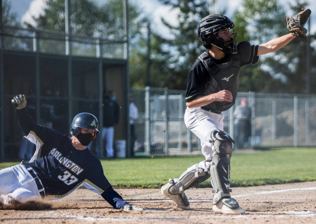 Arlingtons Nick Salstrom slides into home to score during a game against Marysville Getchell on May 7, 2021, in Arlington. (Olivia Vanni / The Herald)