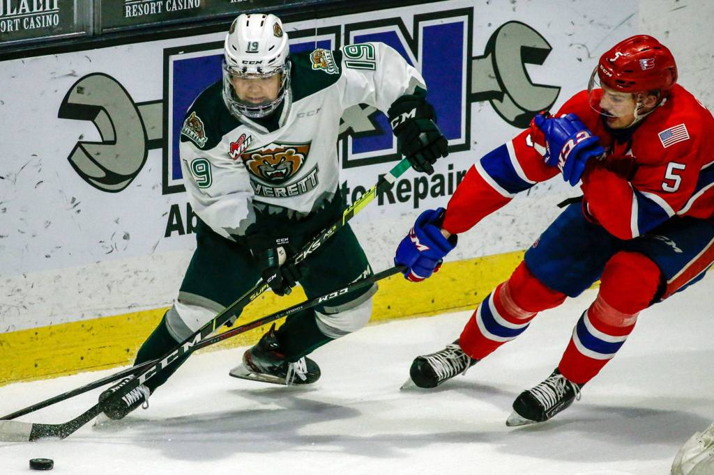 The Silvertips Matthew Ng (left) and the Chiefs Jordan Chudley vie for control the puck during a game on May 7, 2021, at Angel of the Winds Arena in Everett. (Kevin Clark / The Herald)