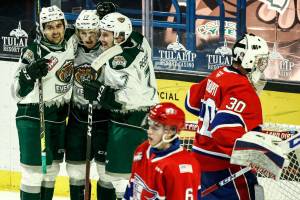 Silvertips' Cole Fonstad (left -right) Jackson Berezowski and Ethan Regnier celebrate Berezowski's goal in the second period against Chiefs' Mac Gross (6) and Mason Beaupit (30) during the final home game Friday night at Angel of the Winds Arena in Everett on May 7, 2021.  (Kevin Clark / The Herald)