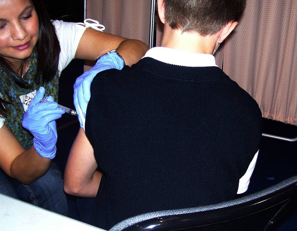 Cinda Schmidt administers the H1N1 vaccine to John Muhlstein, 11, at a gym on the Tulalip reservation on Nov. 2, 2009. (Julie Muhlstein / The Herald)