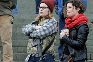 Erin Volz, left, and Andrea Snoke, right, open carry weapons as they take part in a gun-rights rally, Friday, Jan. 18, 2019, at the Capitol in Olympia, Wash. (AP Photo/Ted S. Warren)