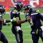 Seattle Seahawks quarterback Russell Wilson (3) celebrates after a touchdown against the San Francisco 49ers with quarterback Geno Smith and linebacker Ray-Ray Armstrong, left, during the second half of an NFL football game, Sunday, Jan. 3, 2021, in Glendale, Ariz. (AP Photo/Rick Scuteri)
