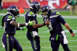 Seattle Seahawks quarterback Russell Wilson (3) celebrates after a touchdown against the San Francisco 49ers with quarterback Geno Smith and linebacker Ray-Ray Armstrong, left, during the second half of an NFL football game, Sunday, Jan. 3, 2021, in Glendale, Ariz. (AP Photo/Rick Scuteri)