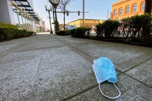 An abandoned face mask rests on the sidewalk along Hewitt Avenue in downtown Everett on April 15. (Sue Misao / The Herald)