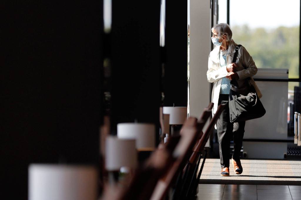 A passenger in the terminal awaiting her flight Wednesday afternoon at Paine Field in Everett. (Kevin Clark / The Herald)