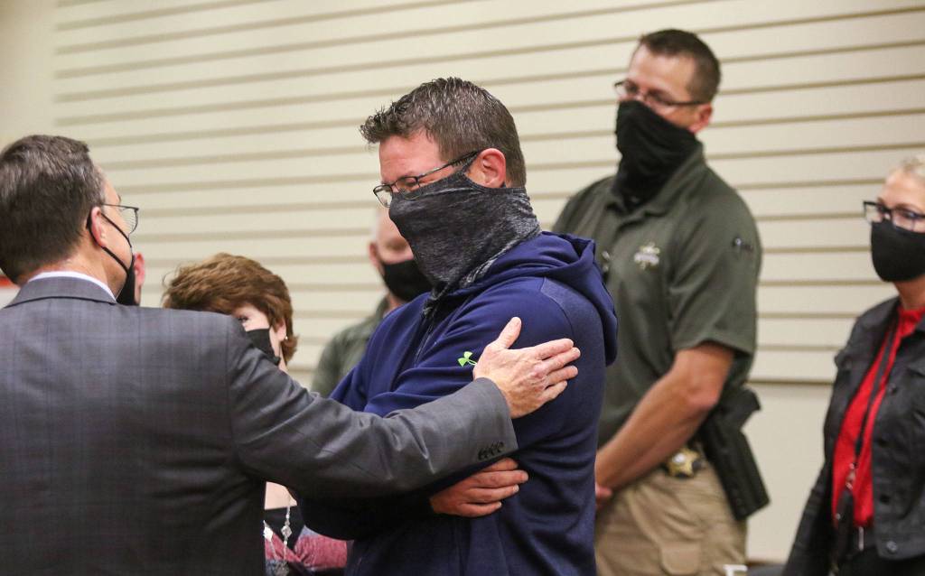 Jarred Haughey (center) talks with deputy prosecutor Craig Matheson (left) after a Snohomish County jury on Tuesday found Jamel Alexander guilty in the murder of Haugheys sister, Shawna Brune. (Andy Bronson / The Herald)
