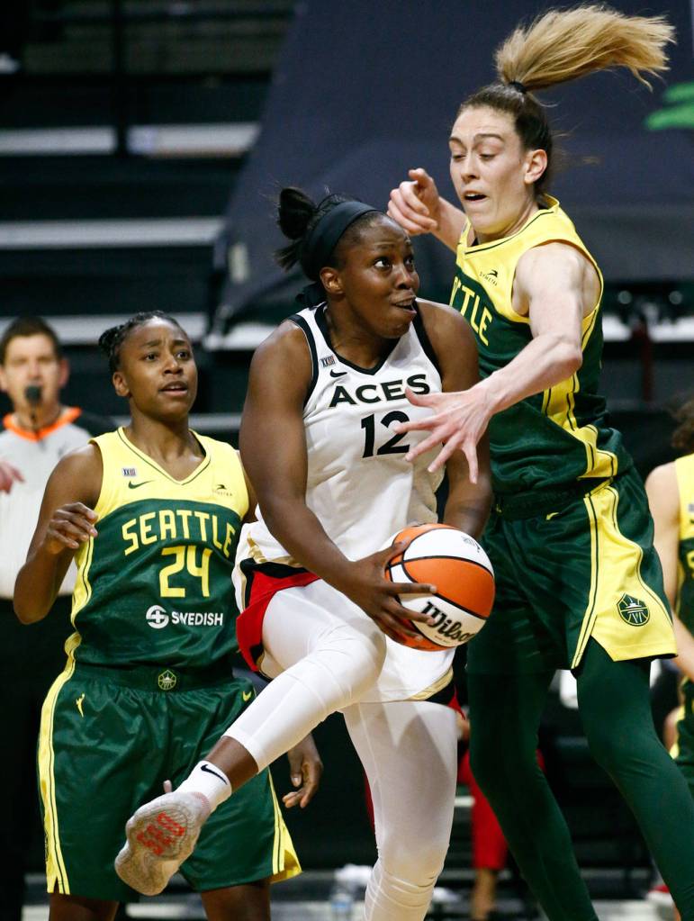 Las Vegas Chelsea Gray drives the lane against Seattles Breanna Stewart (right) with Seattles Jewell Loyd looking on Tuesday night at the Angel of the Winds Arena in Everett on May 18, 2021. (Kevin Clark / The Herald)