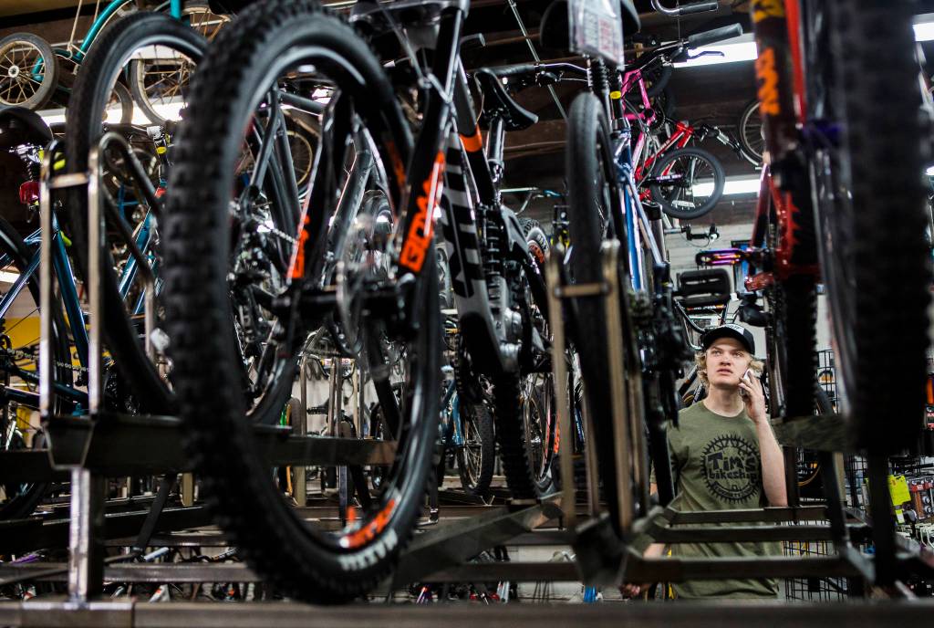 Gavin Buchanan checks inventory on a bike for a customer over the phone Friday at Tims Bike Shop in Everett. Owner Jay Hiester ordered bikes a year out, the first time hes had to do so in 21 years. (Olivia Vanni / The Herald)