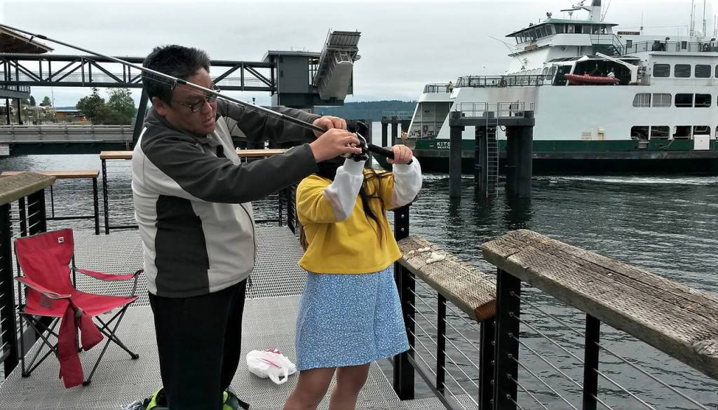 Do Lee helps his 10-year-old daughter Allison with her gear at the new fishing pier near the Mukilteo ferry terminal Sunday. (Julie Muhlstein / The Herald)