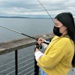 Allison Kim, 10, awaits a bite as she fishes at the new fishing pier Sunday near the Mukilteo ferry terminal. (Julie Muhlstein / The Herald)