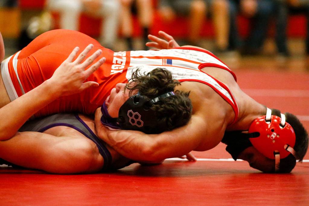 Stanwoods Issac Ortega (top) works to pin Lake Stevens Ethan West during a match on May 20, 2021, at Stanwood High School. Lake Stevens won 48-33. (Kevin Clark / The Herald)