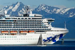 In this photo taken Wednesday, May 30, 2018, a sail boat maneuvers near a large cruise ship near Juneau, Alaska. Congress has voted to let large cruise ships sail directly from Washington state to Alaska without stopping in Canada, a step that could clear the way for cruises later this year. The legislation approved by the House on Thursday, May 20, 2021 goes to President Joe Biden, who is expected to sign it. (AP Photo/Becky Bohrer, file)
