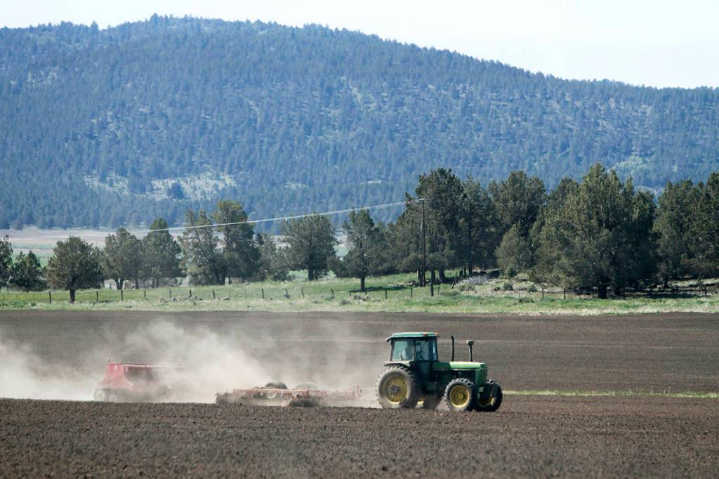 In this 2015 photo, a tractor works a parcel of farm land in the Klamath Basin near Klamath Falls, Oregon. (Dave Martinez/The Herald And News via AP, File)