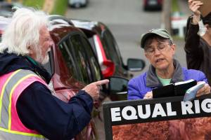 Pro-choice protester Rick Pollock confronts an anti-abortion protester who goes by the name Patty, as they stand shoulder to shoulder in front of the Planned Parenthood Building on 32nd Street on Wednesday, May 26, 2021 in Everett, Washington. The Everett Police Department has ended enforcement of time-place-manner restrictions around Planned Parenthood during weekly demonstrations that separated pro-choice and anti-abortion crowds onto different areas of sidewalk across the street from the Planned Parenthood clinic. (Andy Bronson / The Herald)