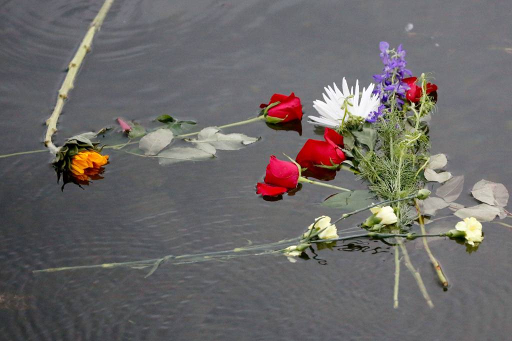 Flowers are placed on the still waters of Lake Stevens on the one-year anniversary of the death of George Floyd. (Kevin Clark / The Herald)