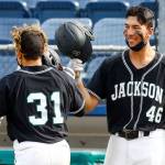 Hellman congratulates teammate Ryan Contreras during a game this spring. (Kevin Clark / The Herald)