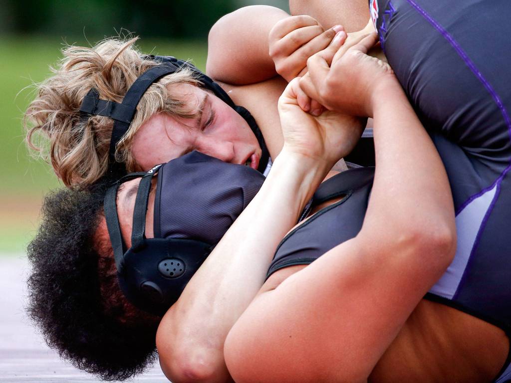 Cascades Daniel Erickson (top) wrestles Kamiaks Vincent Johnson during an outdoor dual meet on Wednesday afternoon at Cascade High School in Everett. Kamiak won 43-42 on forfeit criteria. (Kevin Clark / The Herald)
