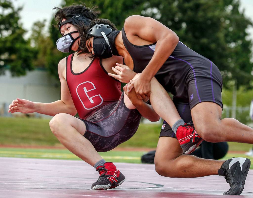 Cascades Thomas Phan (left) wrestles Kamiaks Jaden Beins during an outdoor dual meet on Wednesday afternoon at Cascade High School in Everett. Kamiak won 43-42 on forfeit criteria. (Kevin Clark / The Herald)