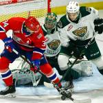 Chiefs Adam Beckman (left) and Silvertips Zach Ashton struggle for the puck in front of Silvertips Dustin Wolf during the final home game Friday night at Angel of the Winds Arena in Everett on May 7, 2021. (Kevin Clark / The Herald)