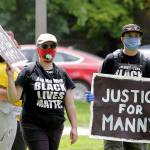 A protester holds a sign that reads Justice for Manny on June 5, 2020, in Tacoma, during a protest against police brutality and the death of George Floyd. (AP Photo/Ted S. Warren)